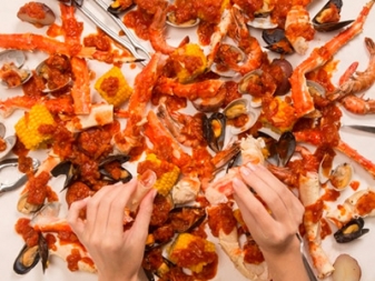手づかみで豪快に食べるシーフード「クラッキン・キングクラブ」